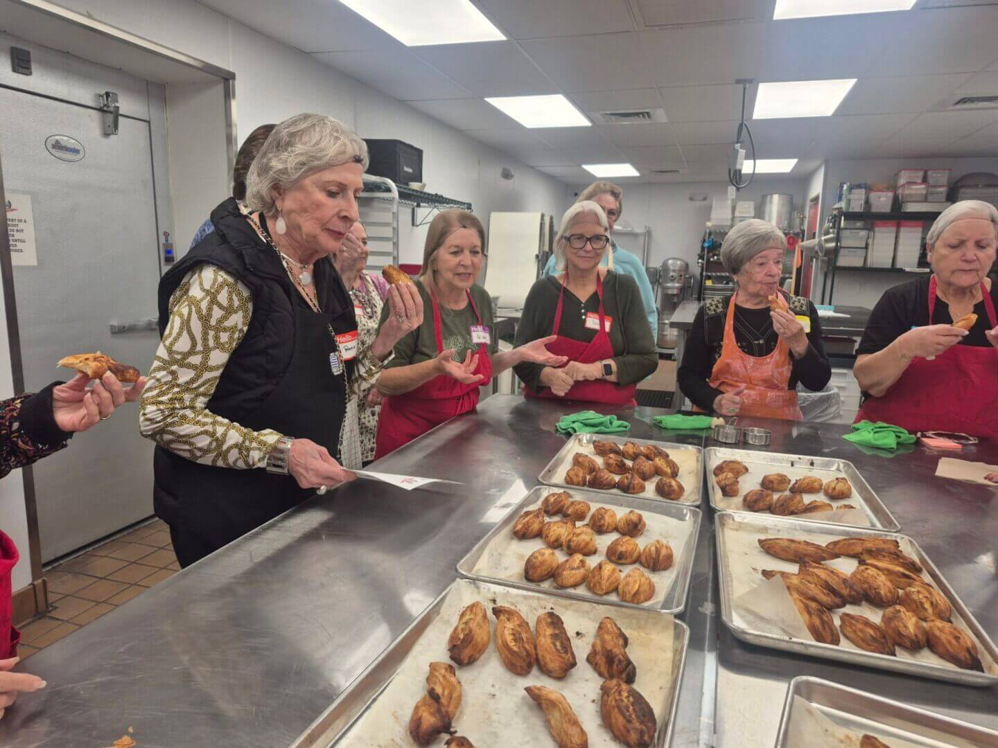 Women sampling baked pastries in community kitchen