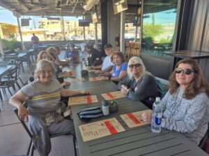 Smiling group dining at outdoor restaurant table