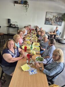 Women gathered around long table sharing lunch