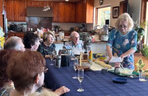 Woman showing recipe steps to attentive diners