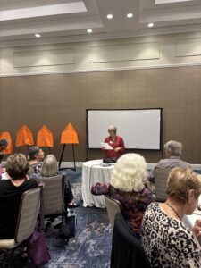 Presenter addressing seated audience in conference room