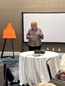 Woman presenting beside projector and projection screen