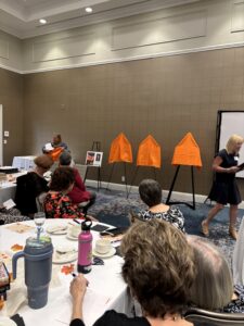 Women at conference with orange easels