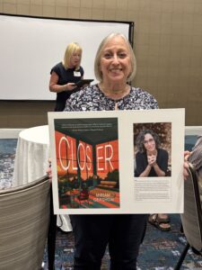 Smiling woman holding book cover poster