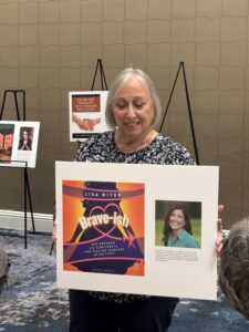 Smiling woman holding a book poster