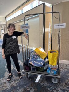 Smiling volunteer beside Tikkun Olam donation cart