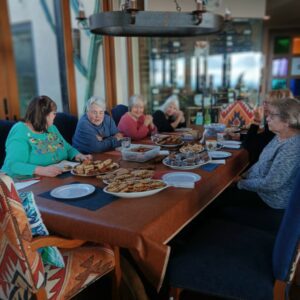 Women gathered around table laden with cookies