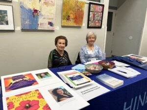 Two women at informational table in gallery