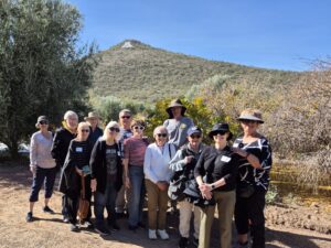 Group of hikers smiling by hillside trail
