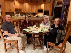 Four adults enjoying dinner at kitchen table