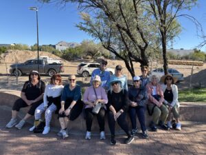Group of people sitting outdoors on stone wall
