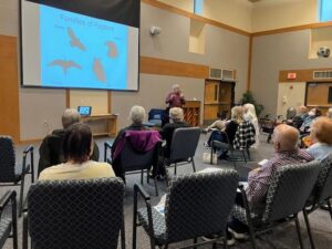 Presenter showing raptors slide to seated audience