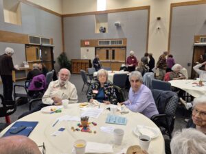 Seniors socializing around table in community room