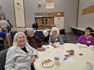Seniors smiling at community breakfast table