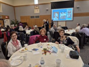 Senior women enjoying community luncheon with presentation
