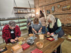 Women assembling mosaic tiles at craft workshop