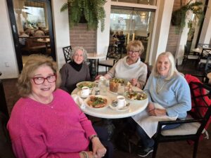 Four women dining together at cafe table