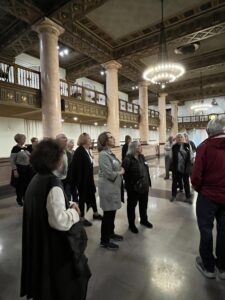 Visitors admiring ornate hall with chandelier