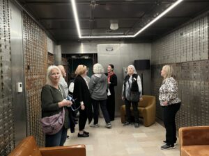Women touring bank vault with safety deposit boxes