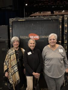 Three women posing before Arizona Theatre Company sign
