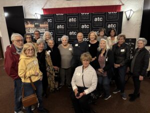 Group of smiling adults at theater backdrop