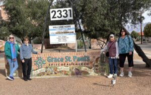 Group posing beside Grace St. Paul's sign