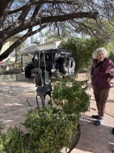 Smiling woman by garden swing and Jeep