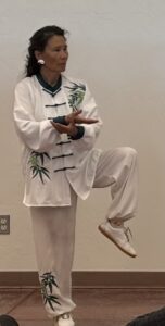 Woman practicing tai chi in bamboo-embroidered uniform