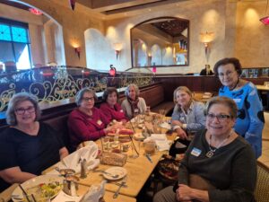 Seven women gathered around a restaurant table