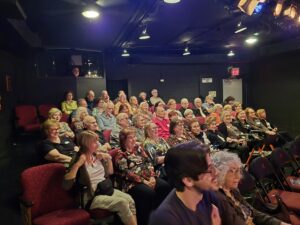 Intimate theater audience seated for performance
