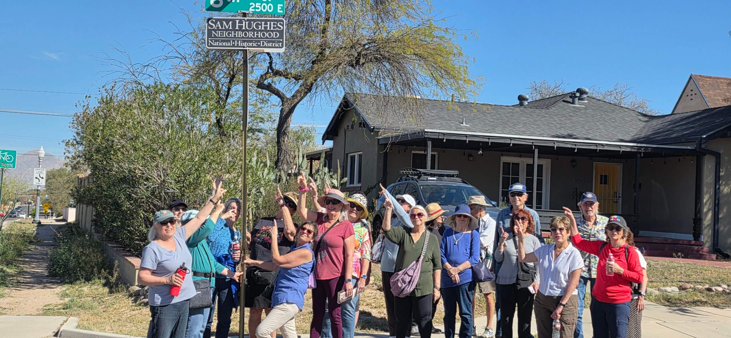 Neighborhood walking group posing by street sign