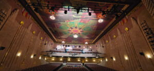 Ornate theater interior with colorful painted ceiling