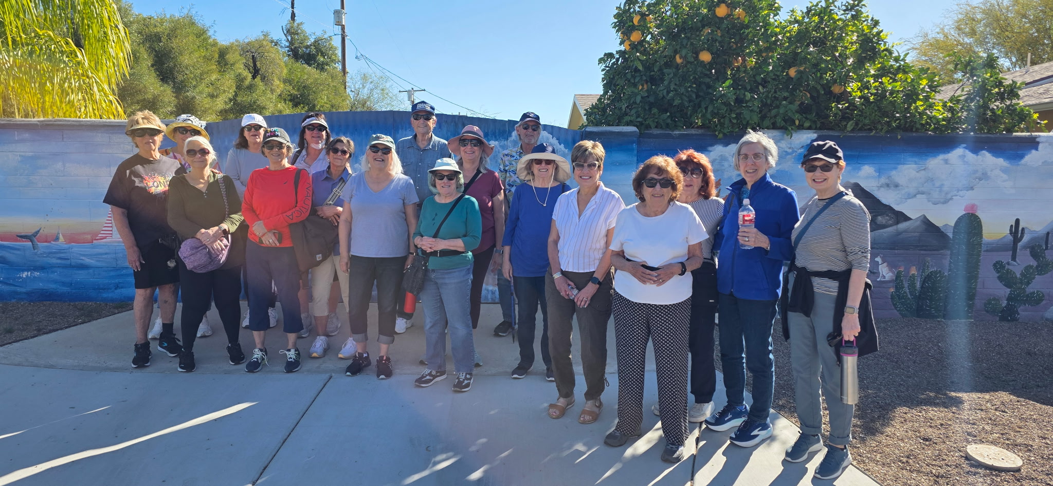 Walking group posing in front of mural