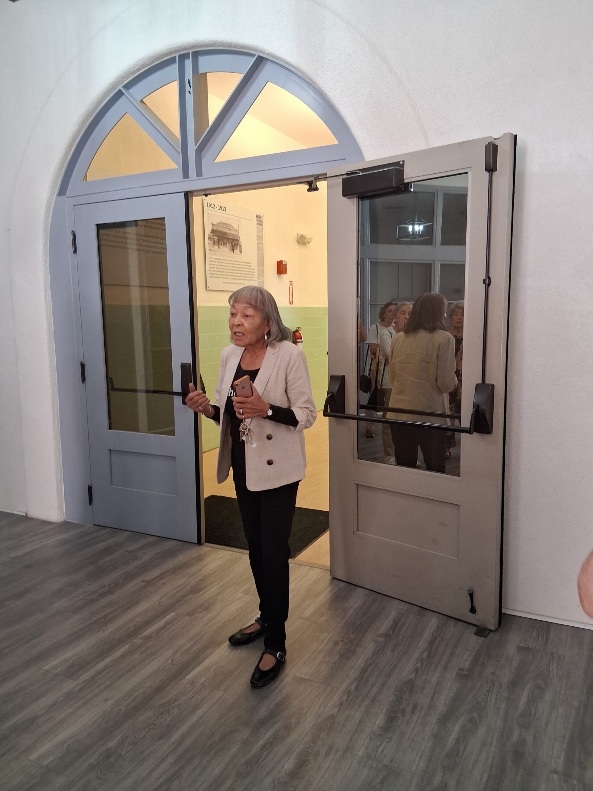 Woman speaking by open arched double doors