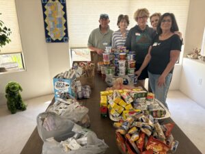 Group of volunteers with donated food table