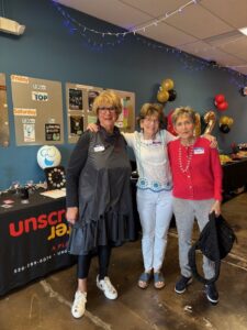 Three women smiling at decorated event
