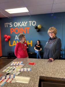 Women at community counter beneath playful wall slogan