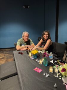 Two people smiling at flower-adorned table