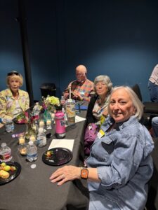 Smiling older adults gathered around table