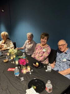 Four seniors smiling at a decorated table