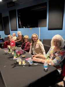 Smiling women seated at floral-decorated table