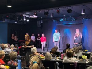 Audience watching community theater performance on stage