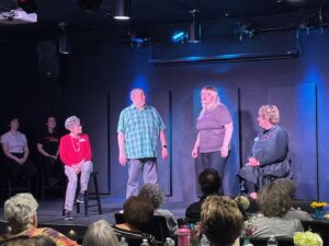 Community theater ensemble performing on small stage