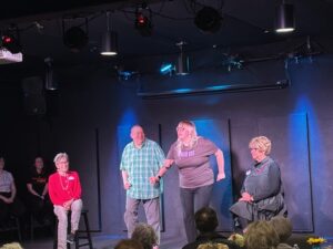 Improv troupe performing on small black box stage
