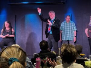 Performer gestures dramatically as audience watches