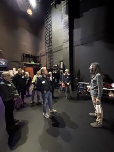 Group touring theater backstage with guide