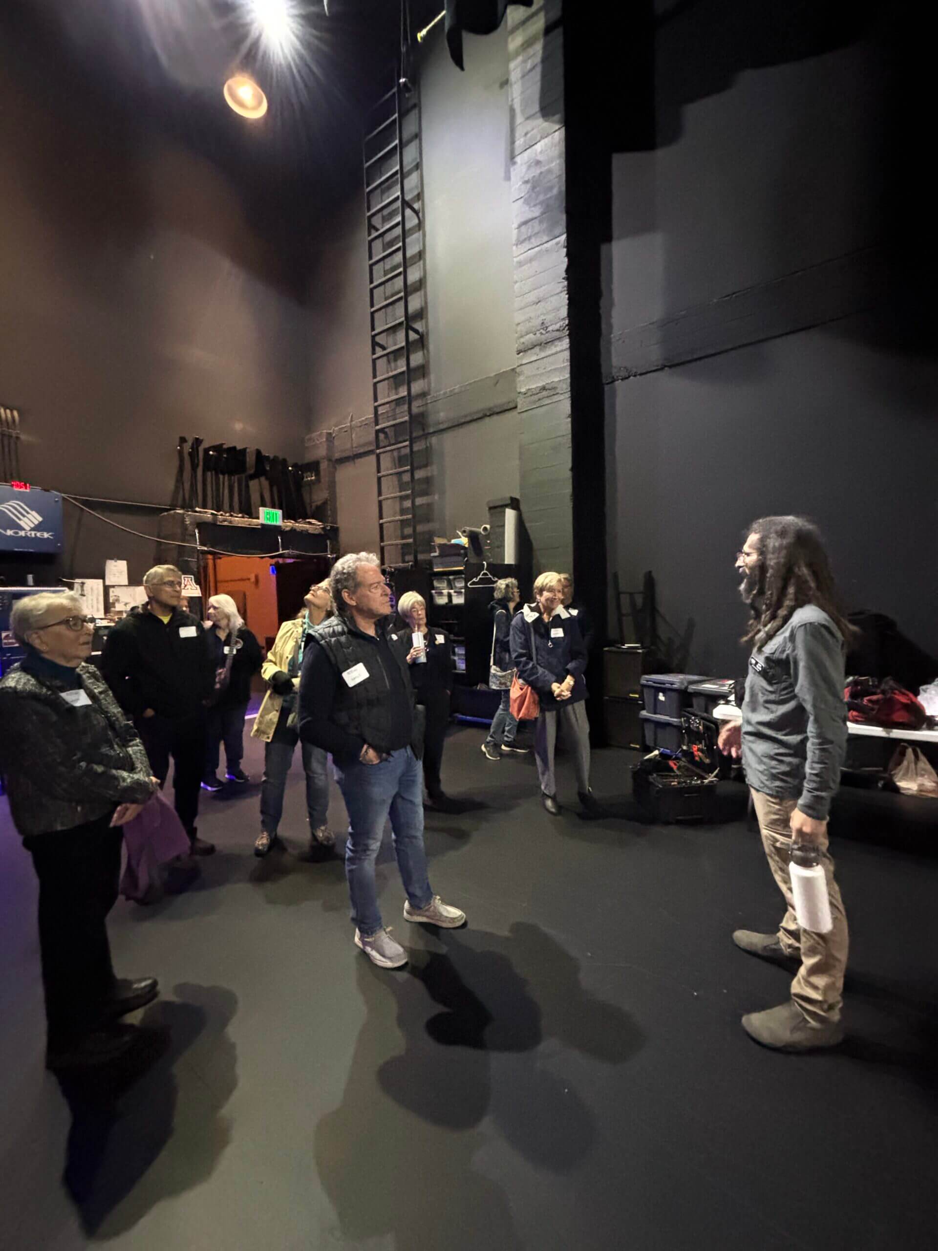 Group touring theater backstage with guide