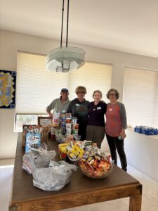 Four volunteers organizing food donations on table