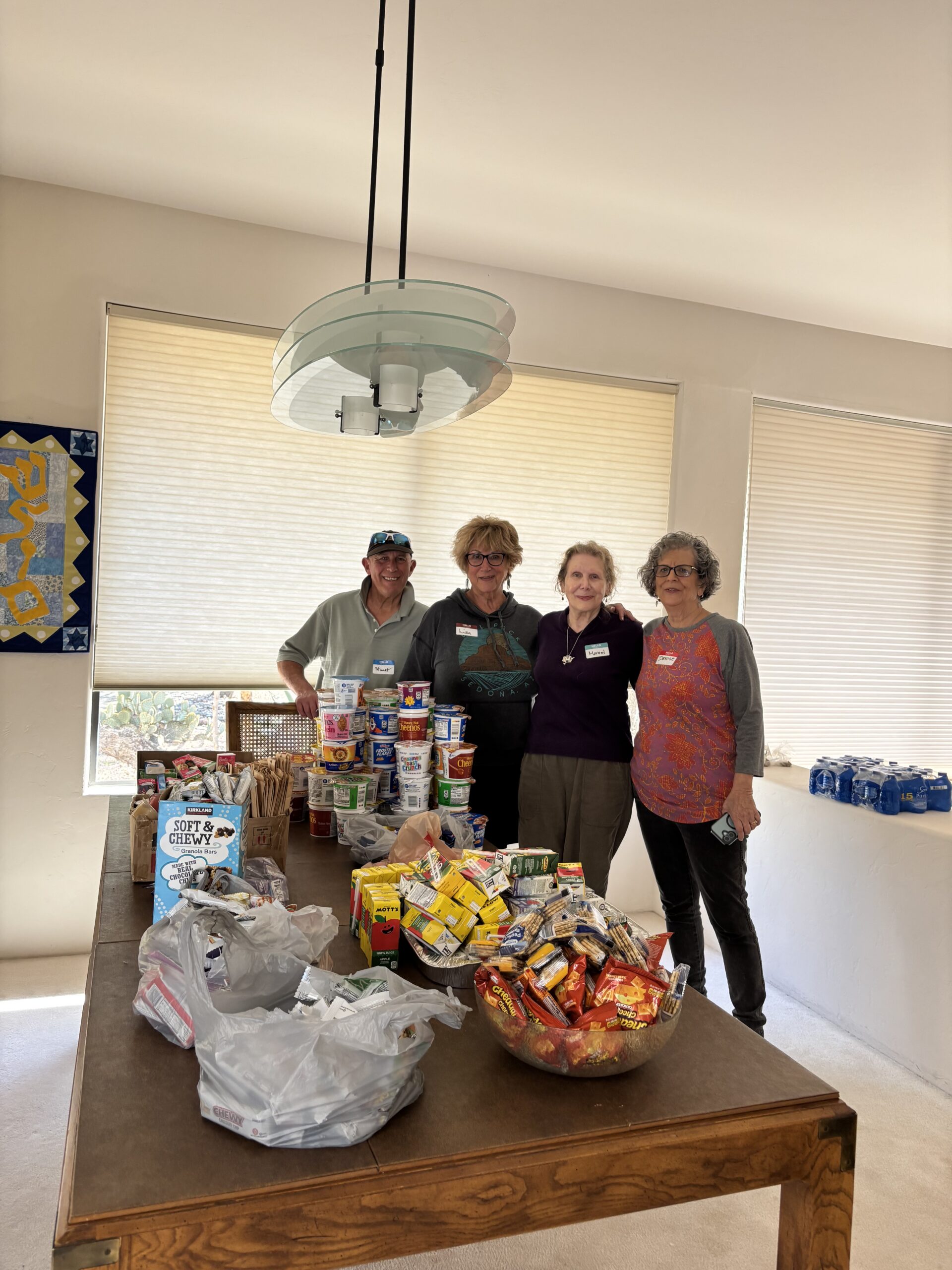 Four volunteers organizing food donations on table