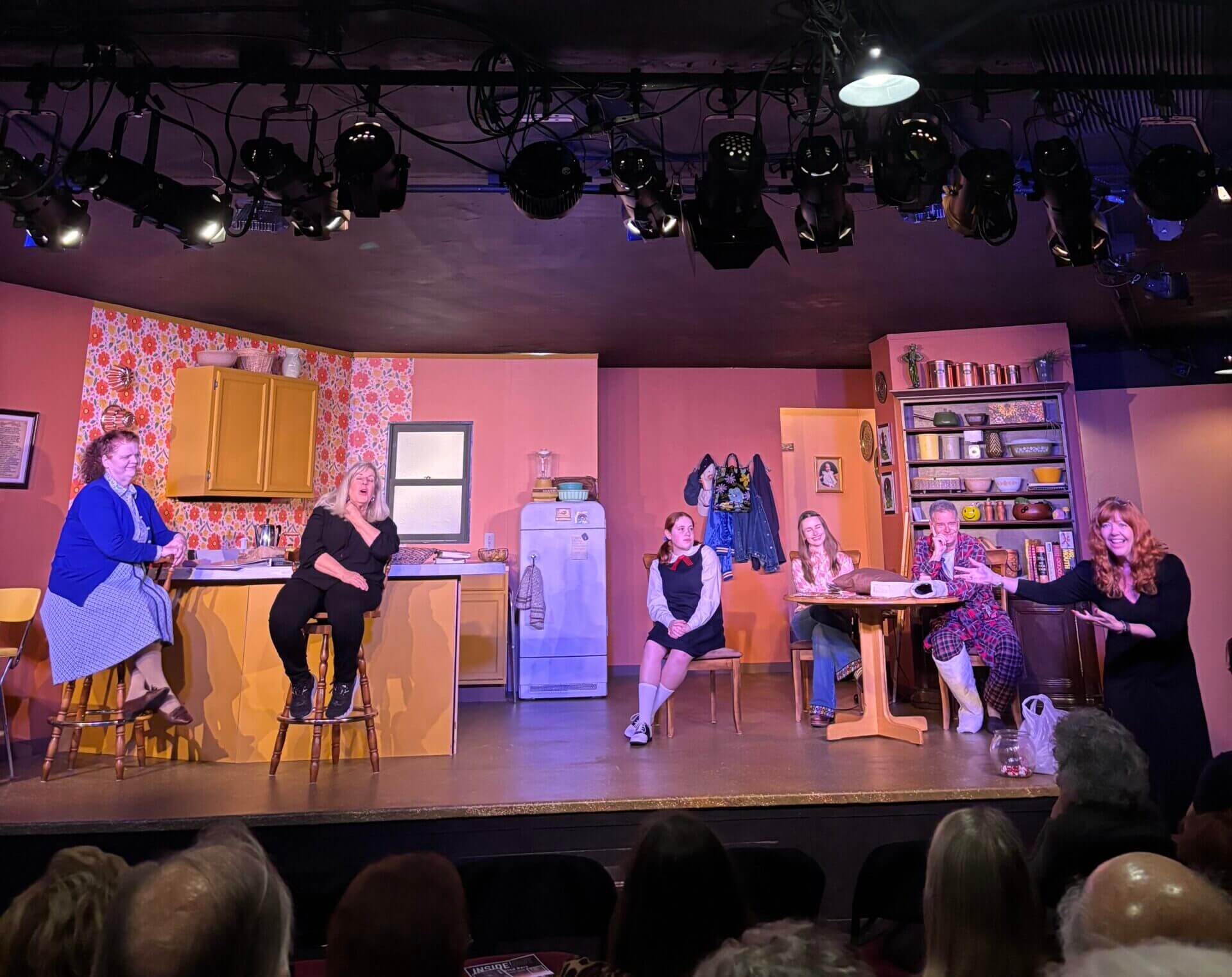 Women onstage in retro kitchen set